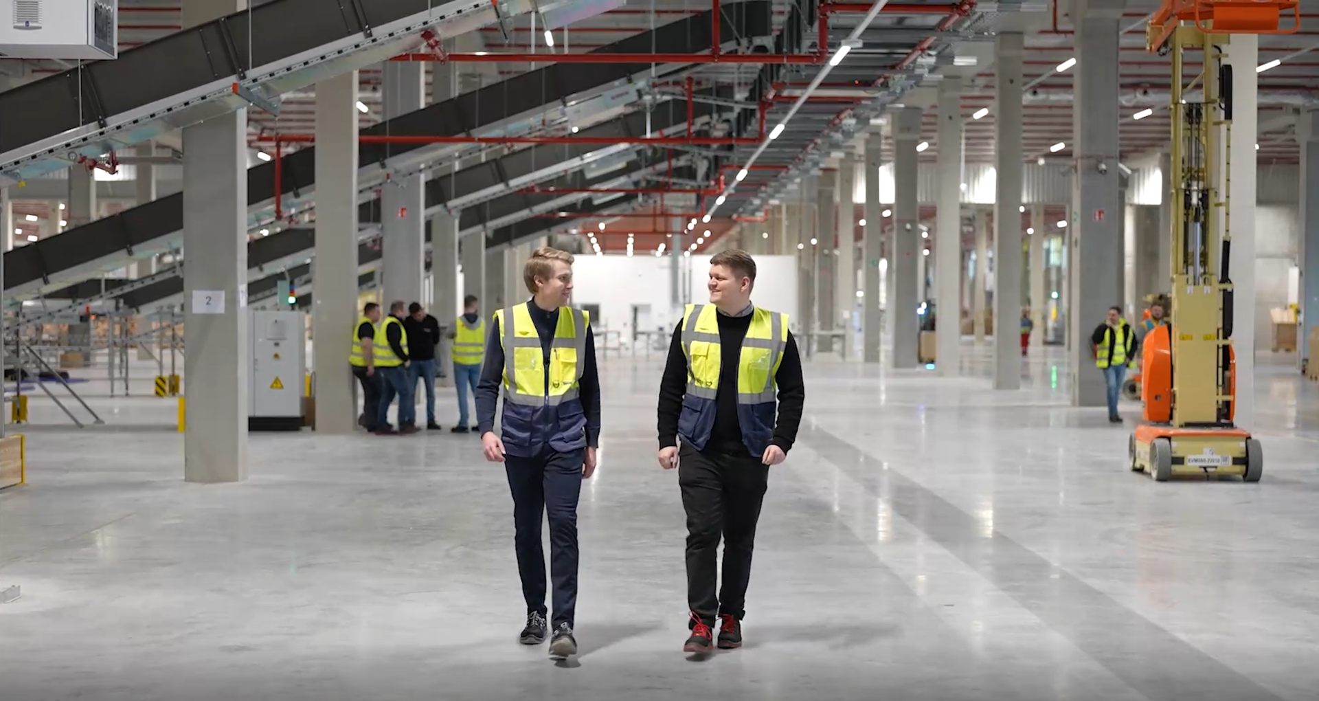 Logistikplaner:innen in einer modernen Lagerhalle bei Metroplan. Mitarbeitende planen und optimieren Logistikprozesse in einem automatisierten Logistikzentrum.